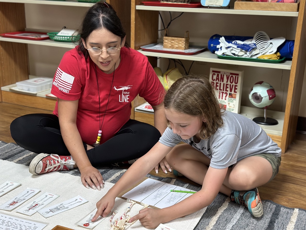 kid coloring guided by teacher