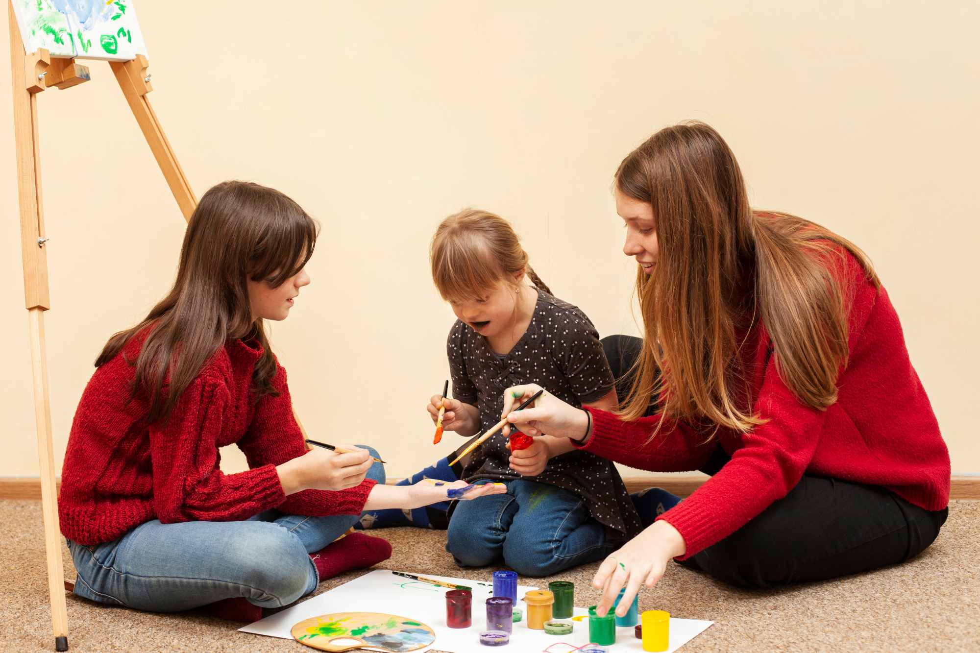 girl with down syndrome painting with colors